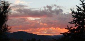 Image of sunset over mountains from whisper creek arvada