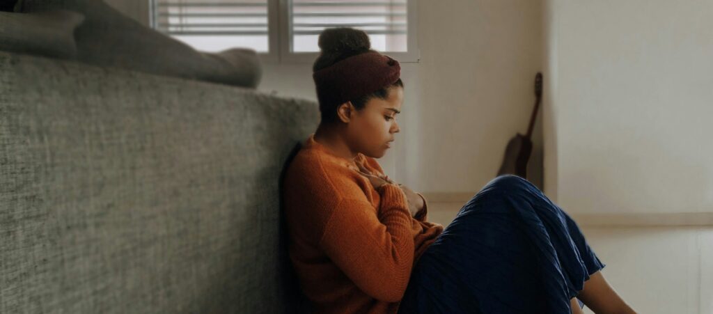 Image of woman leaning against couch with anxiety